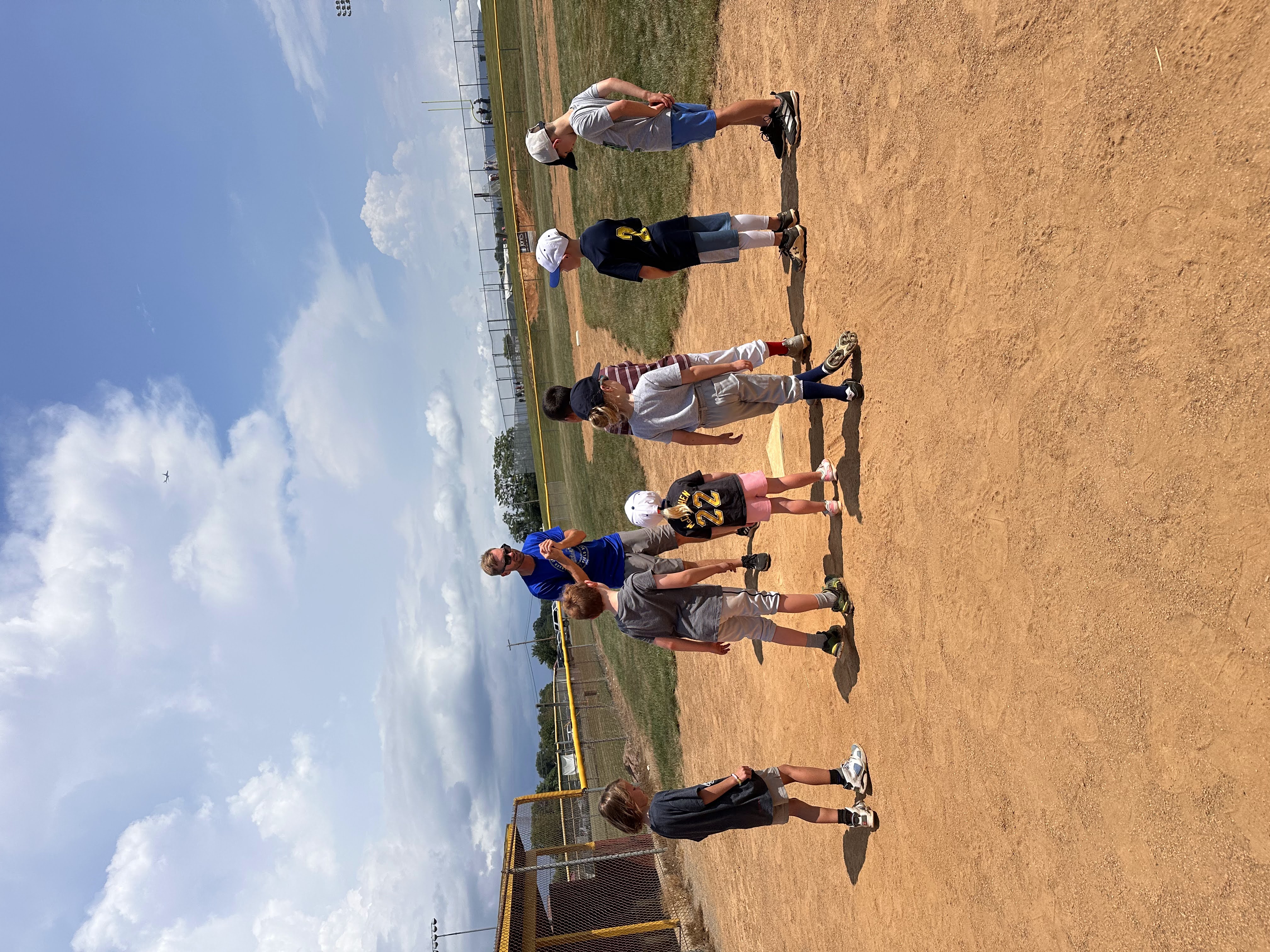 Coach Mark coaching kids on the baseball field
